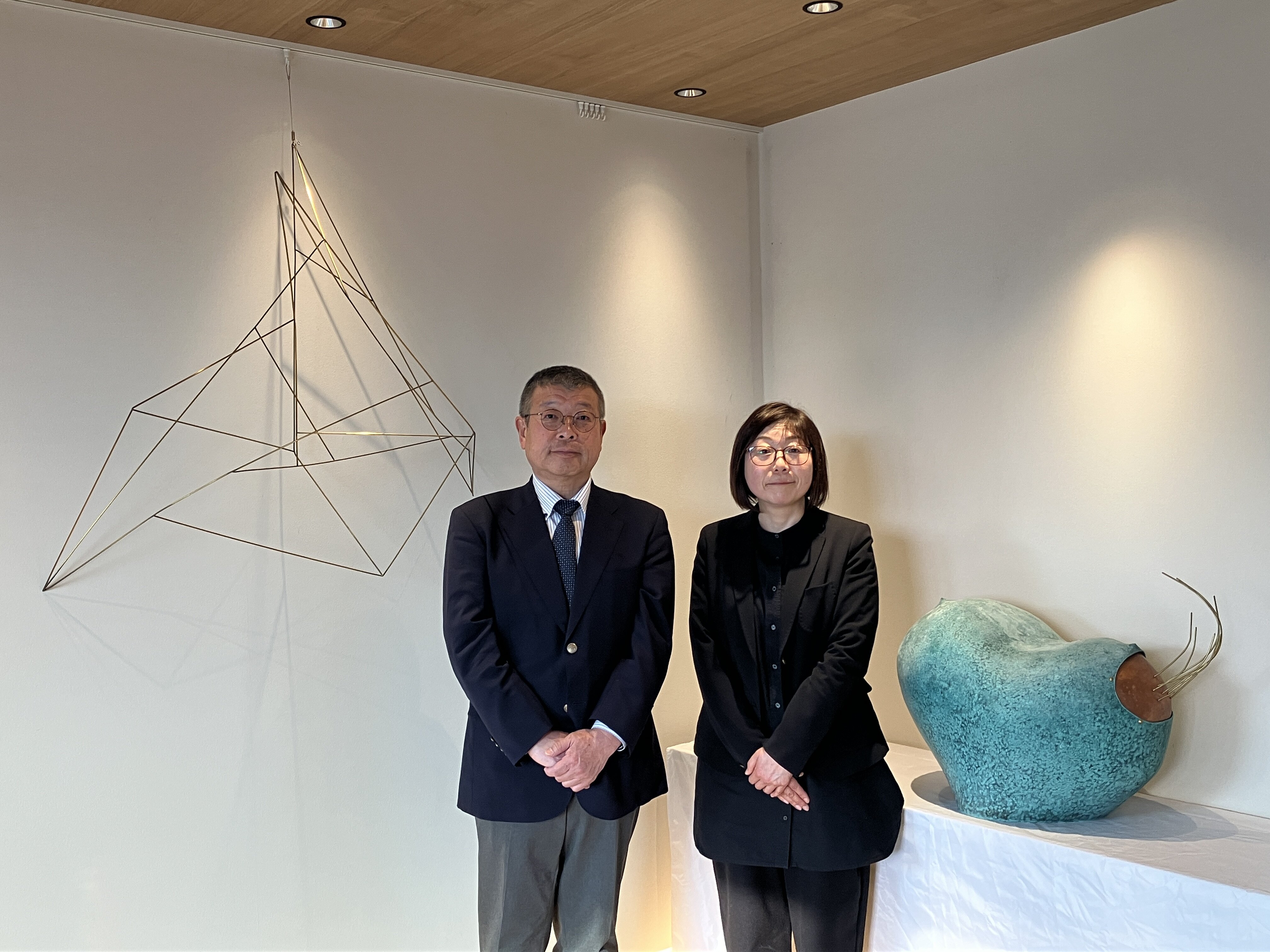 ＜神峰クラブ玄関ロビーでの展示の様子＞ （右から鍛金作家：友常 みゆき 氏、茨城事業所 副所長:森井 健次 氏）